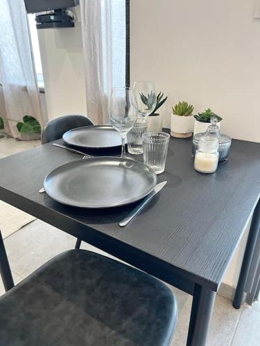 - une table avec deux assiettes et des verres à vin dans l'établissement Studio tout équipé avec parking, à La Rochelle