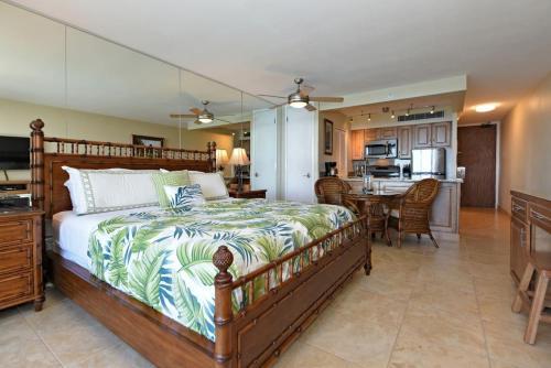 a bedroom with a large bed and a kitchen at Mahana 813 in Kahana