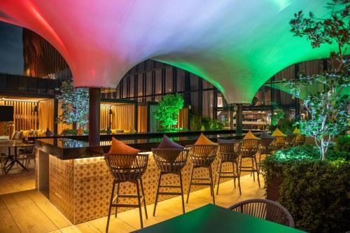 a row of chairs in a restaurant with colorful lighting at Fiesta Americana Viaducto Aeropuerto in Mexico City