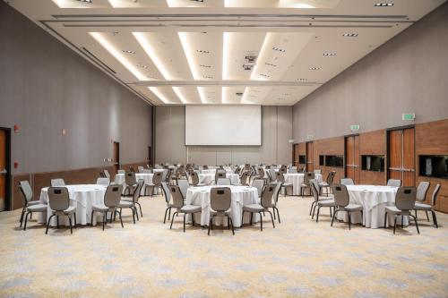 a conference room with white tables and chairs and a screen at Fiesta Americana Viaducto Aeropuerto in Mexico City