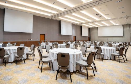 a conference room with tables and chairs and screens at Fiesta Americana Viaducto Aeropuerto in Mexico City
