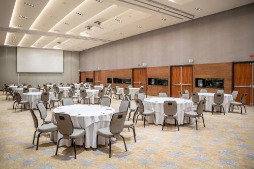 a conference room with tables and chairs and a screen at Fiesta Americana Viaducto Aeropuerto in Mexico City