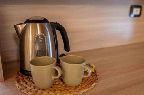 a coffee pot and two cups on a tray at Agriturismo Corte Casa Erminia in Colà di Lazise