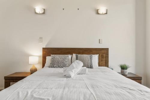 a large white bed with two pillows on it at Mountain Majesty with Poolside Relaxing Getaway in Tamborine