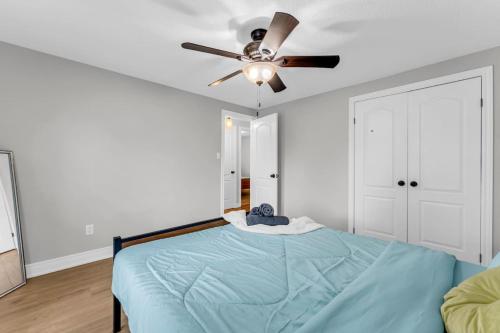 a bedroom with a bed with a ceiling fan at Cozy Home by Niagara Falls in Thorold