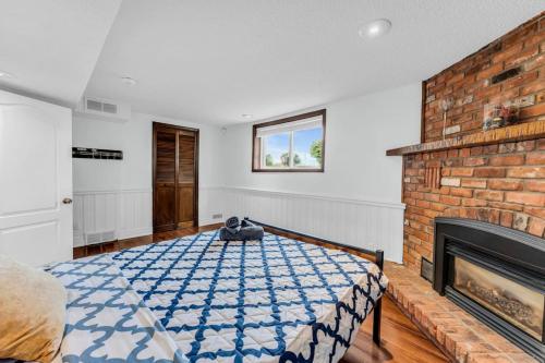 a bedroom with a bed and a brick fireplace at Cozy Home by Niagara Falls in Thorold