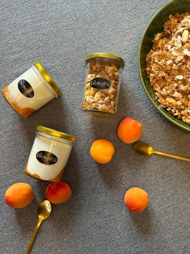 a table with a bowl of granola and two jars of yogurt at Wellness apartmány Český ráj & Biokolna in Lomnice nad Popelkou