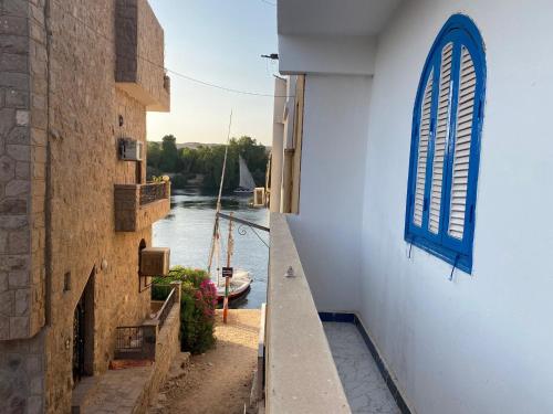 a view of a river from a building with a blue window at La Veranda 陽台 in Aswan
