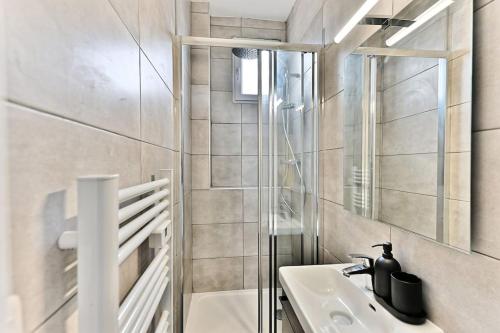 une salle de bain avec un lavabo et un miroir dans l'établissement Appartement Vue panoramique sur la capitale - II, à Puteaux