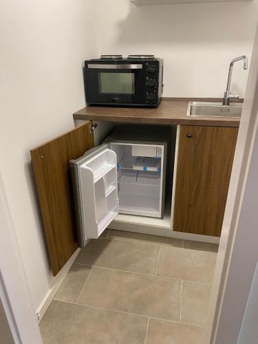a small kitchen with a microwave and a small refrigerator at Bed minus breakfast Den hyggelige kælder in Nykøbing Falster
