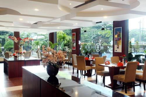 a restaurant with tables and chairs and a large window at Grand Hatika Hotel in Tanjungpandan