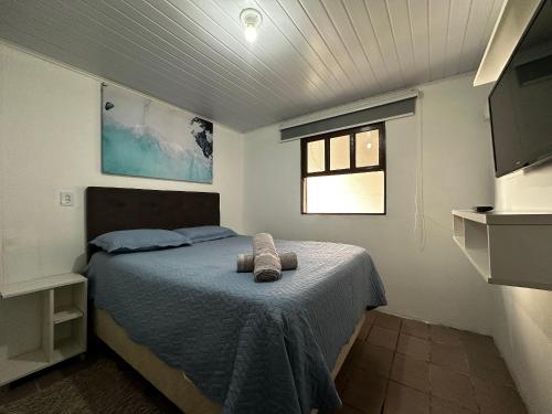 una camera da letto con un letto e una finestra di BS01- Casa com Piscina Aquecida e Churrasqueira a Balneário Barra do Sul