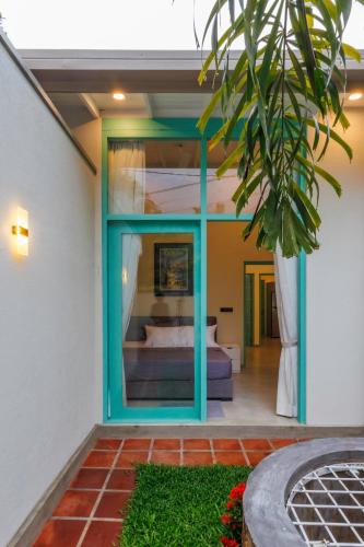 a room with a bed and a glass window at Nomad Nest in Hikkaduwa
