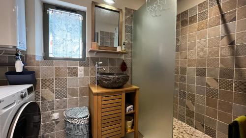 une salle de bain avec un lavabo et une machine à laver dans l'établissement Un Cottage au pied du Ventoux, à Bédoin