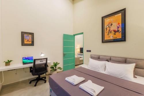 a bedroom with a bed and a desk and a computer at Nomad Nest in Hikkaduwa
