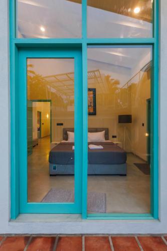 a view of a room with two beds through a window at Nomad Nest in Hikkaduwa