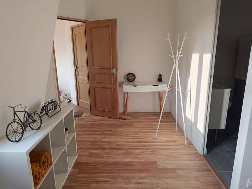 Cette chambre dispose d'un couloir avec une table et un miroir. dans l'établissement Appart sci phlb, à Saint-Rémy-lès-Chevreuse
