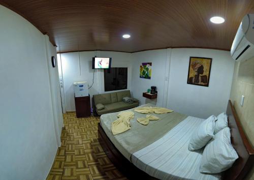 a bedroom with a large bed and a couch at Tortuguero7 lake view in Tortuguero