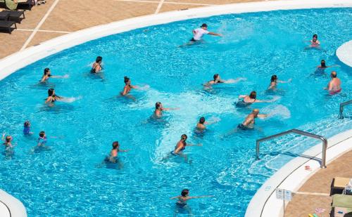 a group of people swimming in a swimming pool at GF Fañabe in Adeje