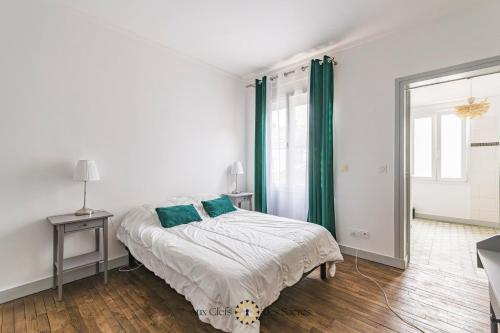 - une chambre blanche avec un lit et des rideaux verts dans l'établissement Maison de ville avec cour Place Luton, à Reims