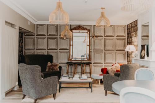 a living room with a couch and two chairs at Les Cabines in Houlgate