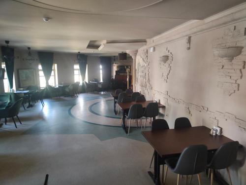 a room with tables and chairs and a wall at Hotel Voskresensky in Sumy