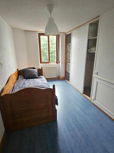 a bedroom with a bed in the middle of a room at relais de la diligence in Morteau