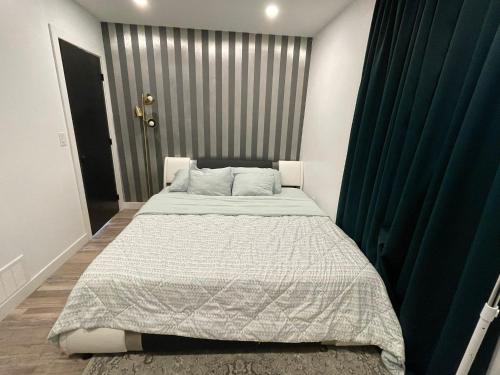 a bedroom with a large bed with a green curtain at Home away from home in Winnipeg