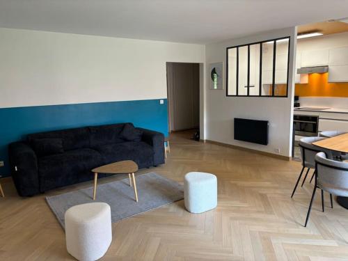 un salon avec un canapé noir et une table dans l'établissement Carré D'OR Dahlia 7 Pers avec Parking, à Le Touquet-Paris-Plage