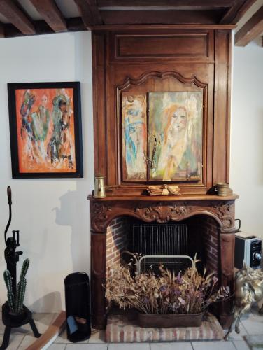 d'une cheminée avec des peintures au-dessus de celle-ci. dans l'établissement Honfleur-Terrasse, à Honfleur