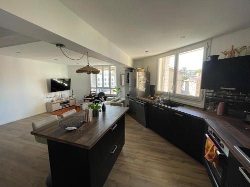 une grande cuisine avec une table et un salon dans l'établissement Bel Appartement T3 tout équipé, à Millau