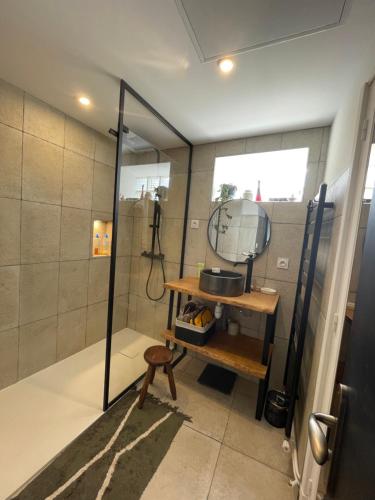 La salle de bains est pourvue d'une douche avec miroir et d'une table. dans l'établissement Bel Appartement T3 tout équipé, à Millau