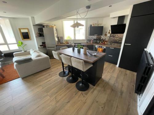 une cuisine et un salon avec une table et un canapé dans l'établissement Bel Appartement T3 tout équipé, à Millau