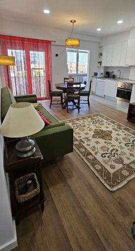 a living room with a green couch and a table at Benfica Flat in Lisbon