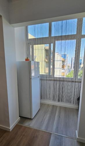 a white refrigerator in a room with a window at Benfica Flat in Lisbon