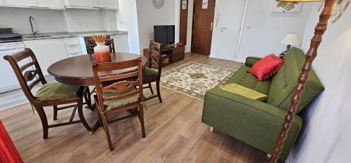 a living room with a green couch and a table at Benfica Flat in Lisbon
