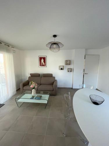 un salon avec un canapé et une table dans l'établissement Appartement 2 chambres en rez de jardin avec piscine, à Cogolin