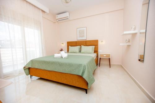 a bedroom with a large bed with a green blanket at Fay's Apartment in Nea Vrasna
