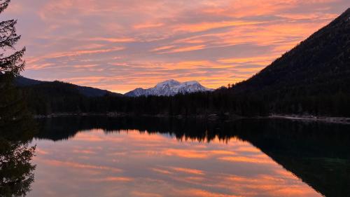 a reflection of a mountain in a lake at sunset at ALPEN EXPERIENCE - CVJM Aktivzentrum Hintersee, Jugendgästehaus in Ramsau