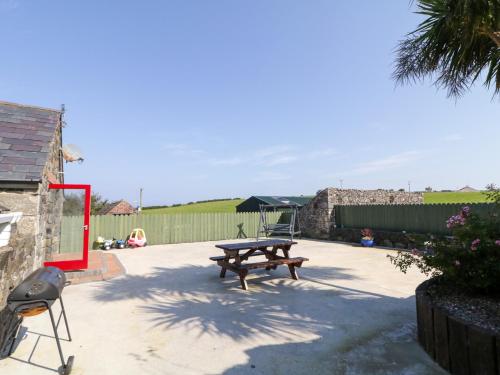 a patio with a picnic table and a grill at Colliers Barn in Ballycastle