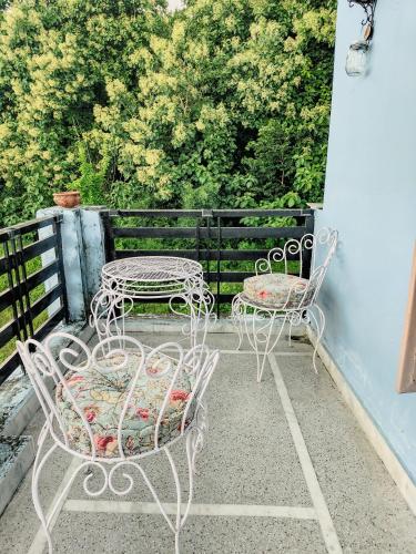 two tables and chairs sitting on a patio at Hoztel Jollygrrant Doon in Rāni Pokhri
