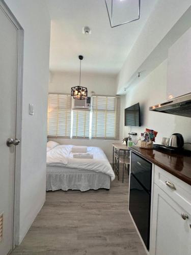 a bedroom with a bed in the middle of a room at Studio One Condominium, Alabang - Bluu - Fiber Wi-Fi, Netflix-ready in Manila