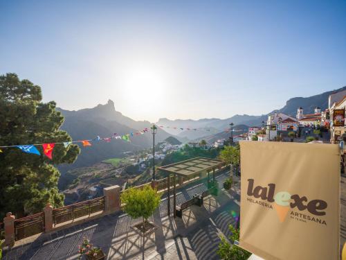 a view of a town with a banner and mountains at Texeda Room Suites in Tejeda