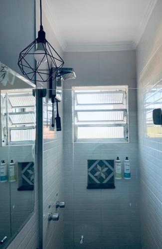 a bathroom with a shower with a mirror and a window at Santo Antônio Hotel Ltda in Angatuba