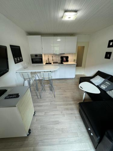 une cuisine avec des armoires blanches et une table et des chaises dans l'établissement Appartment 4 personnes La Bresse, à La Bresse