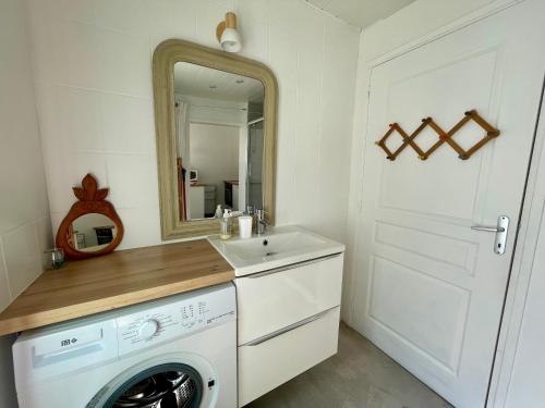 a bathroom with a washing machine and a mirror at Grand Studio centre ville, gare et plage à pied in Pornichet