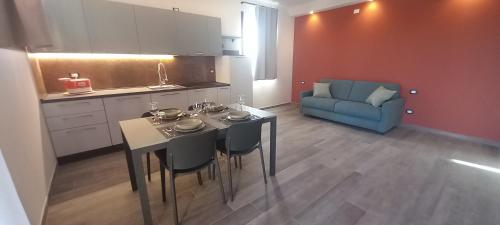 a kitchen with a table and chairs and a blue couch at Agriturismo Corte Casa Erminia in Colà di Lazise