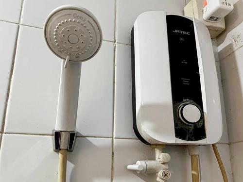 a soap dispenser on a wall next to a sink at 2BR Apt Green Pramuka with Pool & Wi-Fi by 2ndHome in Jakarta