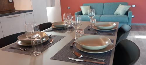 a table with glasses and bowls and plates on it at Agriturismo Corte Casa Erminia in Colà di Lazise