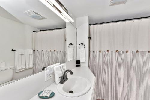 a white bathroom with a sink and a shower at Wilkins Townhouse - 3 Bed, 3 Bath, Walk to Downtown in Natchez